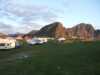 Mobile homes on a field with mountains in the background.