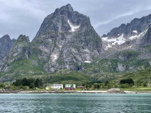 Gamle, vakre hus og bratte fjell i Rafysundet sett fra rib båt.
