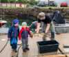 Man showing a fish to two kids